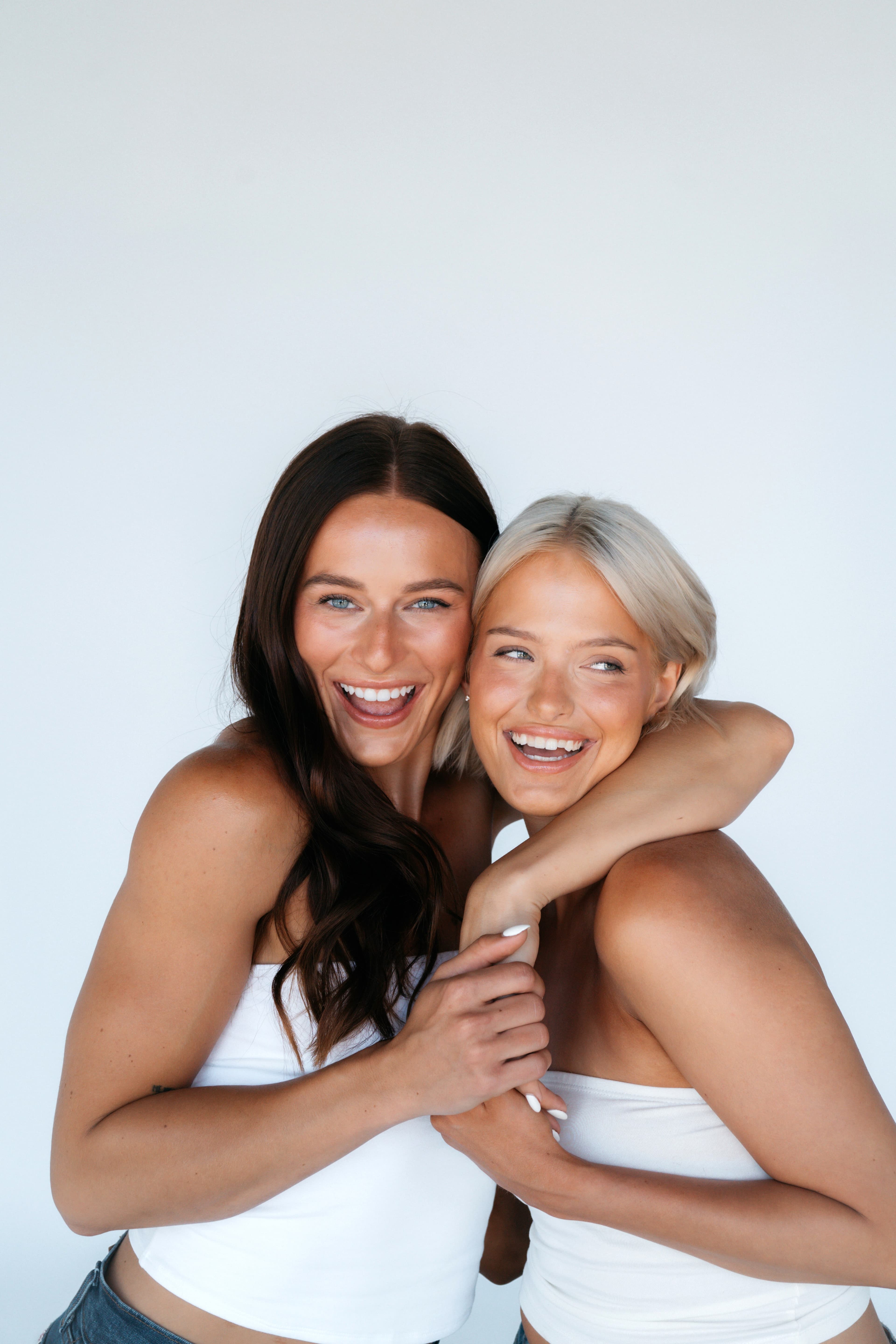 Two friends hugging and laughing
