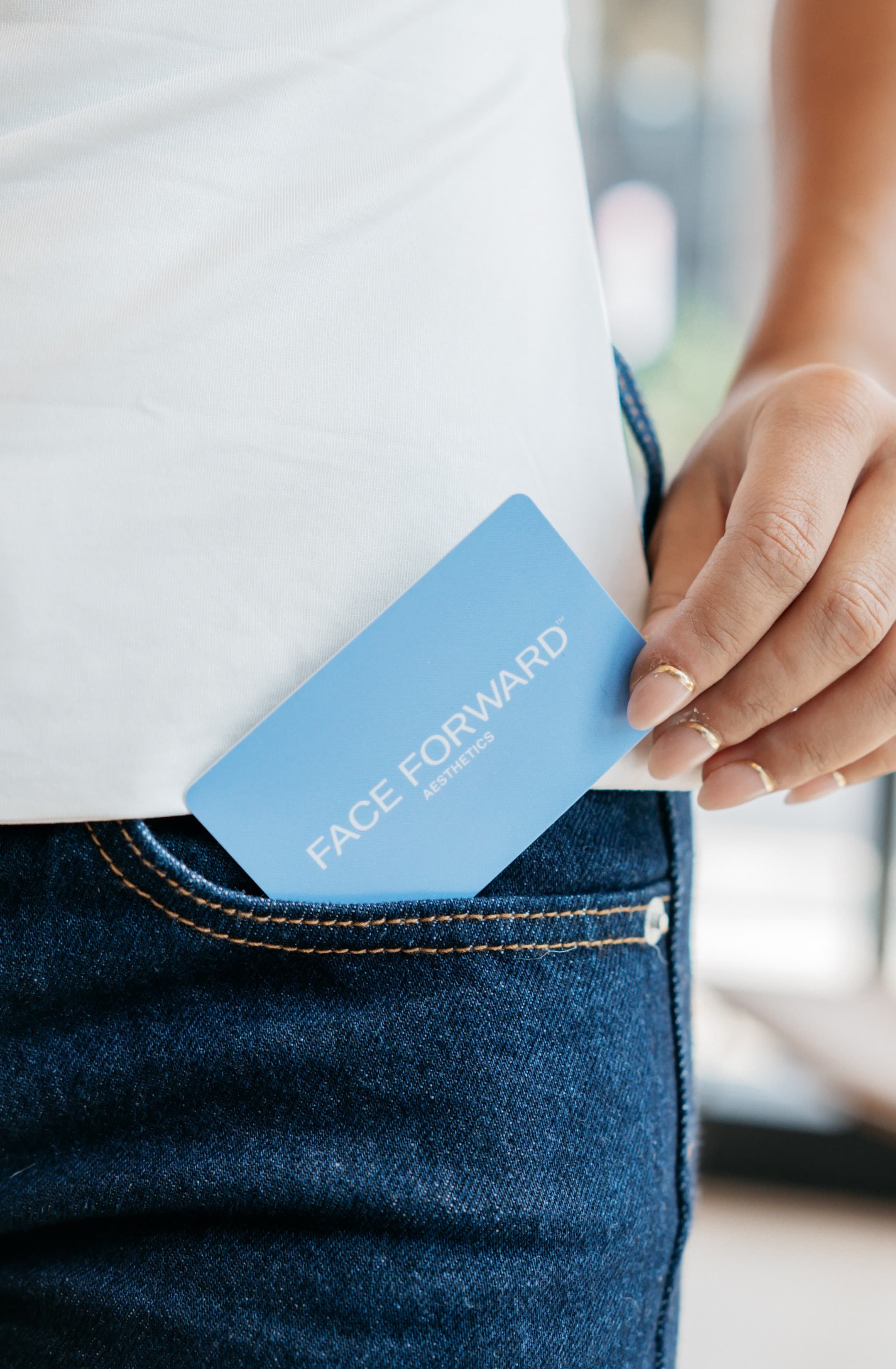 Face Forward business card tucked into a jeans pocket