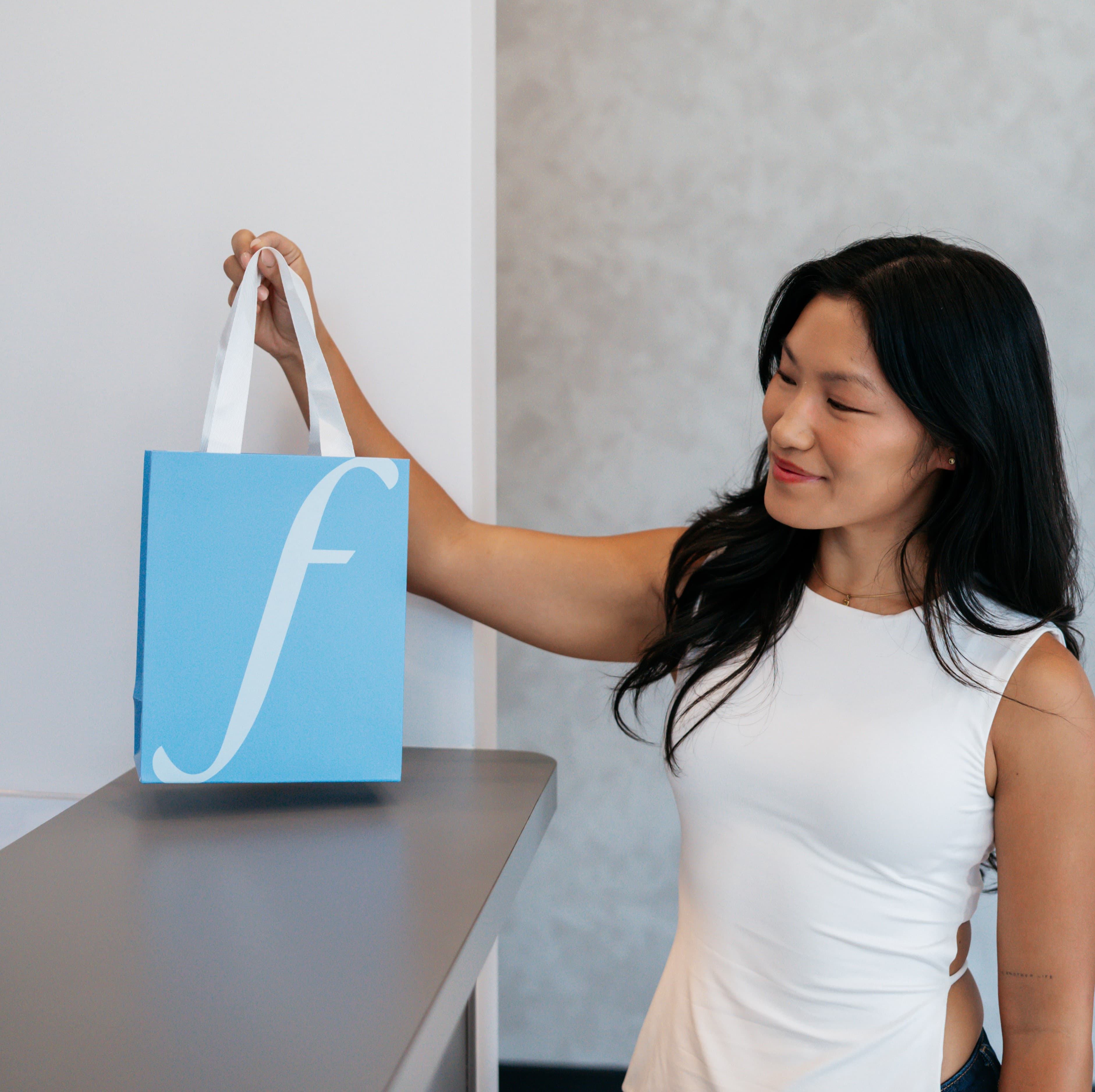 Guest holding a Face Forward Aesthetics gift bag