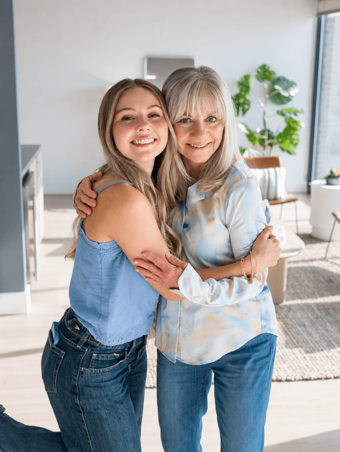 Two women embracing in a bright living room